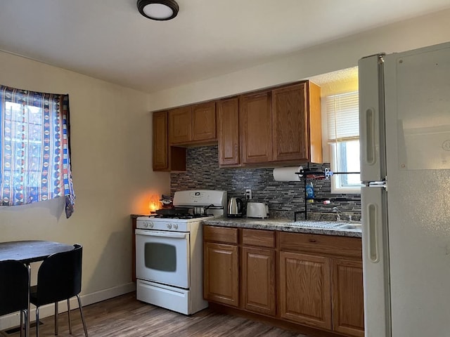 kitchen with tasteful backsplash, dark hardwood / wood-style flooring, and white appliances