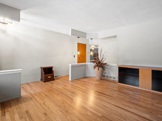 unfurnished room with a notable chandelier and wood-type flooring