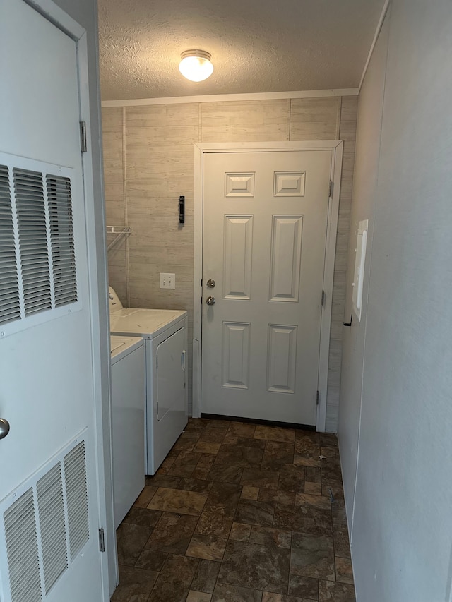 laundry room featuring ornamental molding, a textured ceiling, and independent washer and dryer