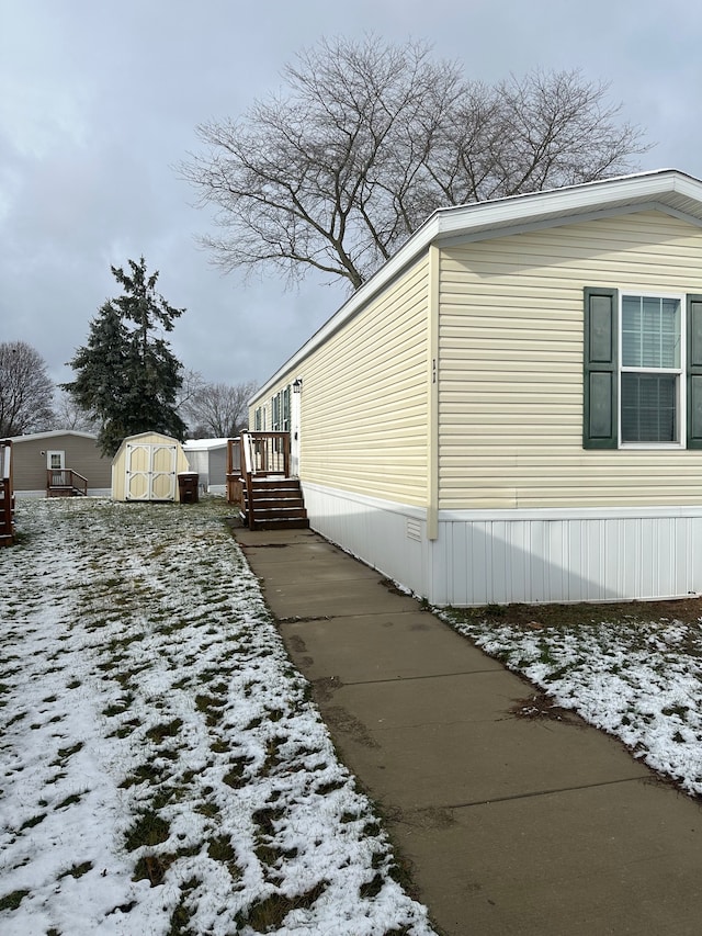 view of snowy exterior featuring a storage unit