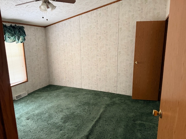 unfurnished room featuring plenty of natural light, ceiling fan, and carpet floors