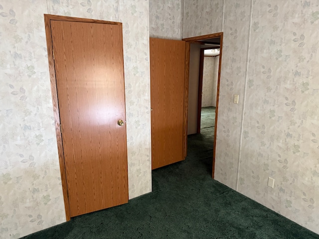 unfurnished room featuring dark colored carpet