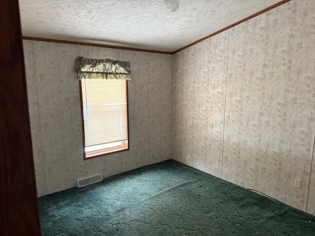 empty room featuring carpet flooring, a textured ceiling, and ornamental molding