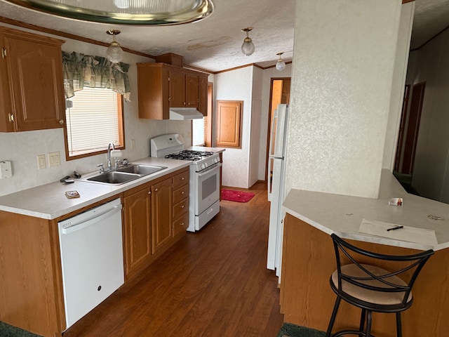 kitchen with a breakfast bar, white appliances, crown molding, sink, and dark hardwood / wood-style floors