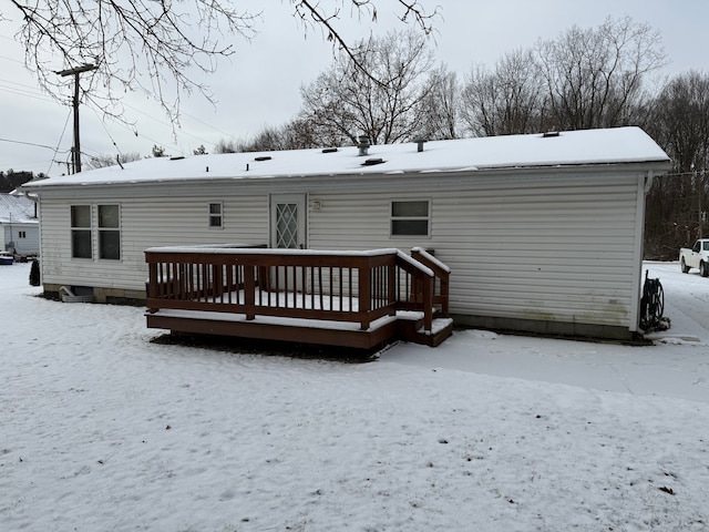 snow covered property with a deck