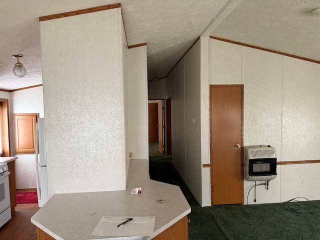 kitchen featuring a textured ceiling, heating unit, white appliances, and dark colored carpet