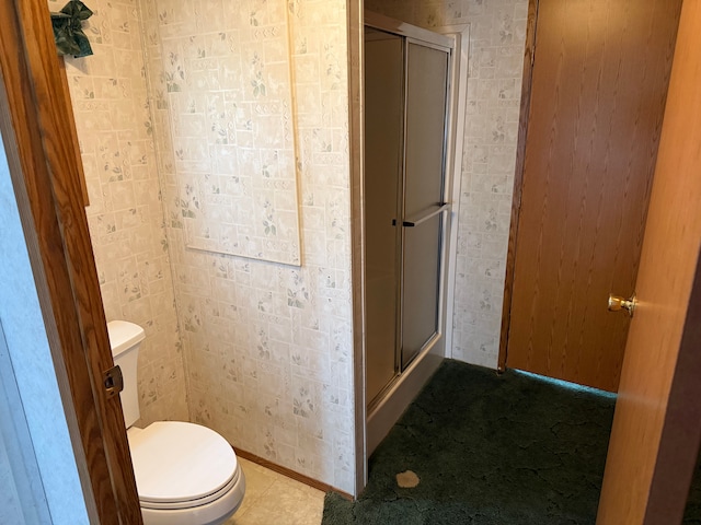 bathroom with toilet and a shower with door