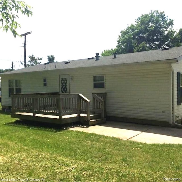 rear view of house with a yard, a deck, and a patio area