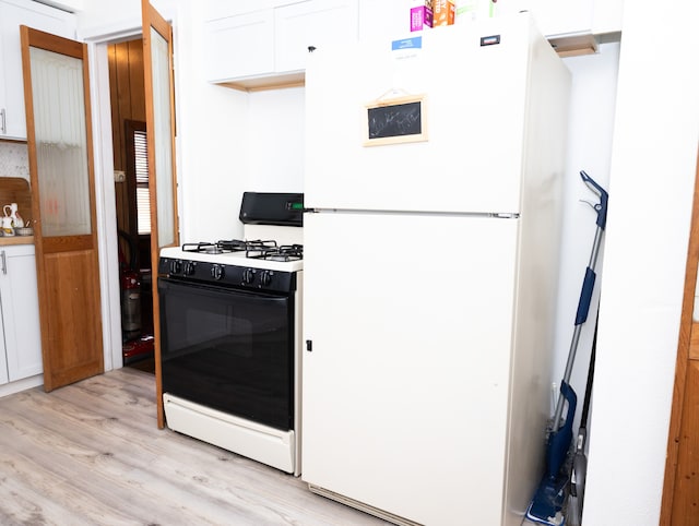 kitchen with white cabinetry, light hardwood / wood-style floors, and white appliances