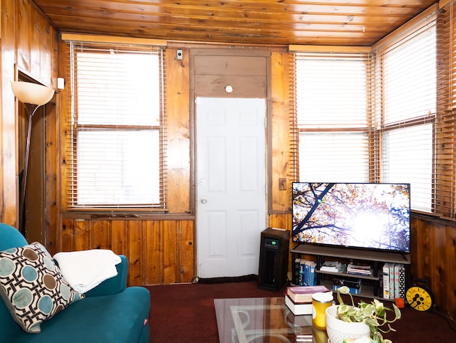 living room featuring a wealth of natural light, wooden ceiling, and wooden walls