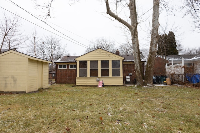 back of property with a sunroom, a shed, and a yard