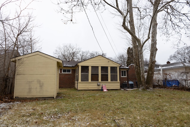 rear view of house with a lawn and a sunroom