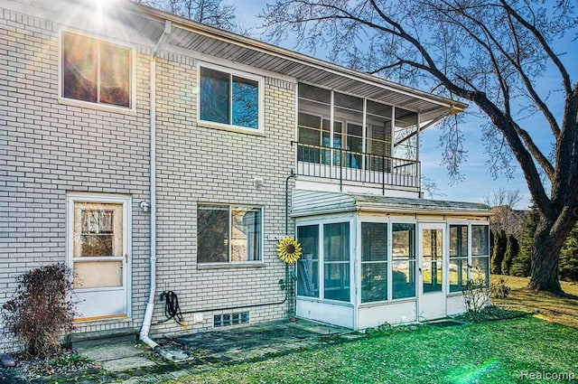 back of house with a lawn and a sunroom