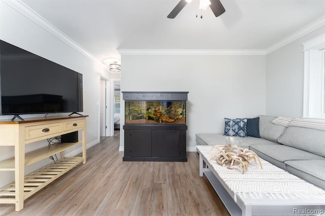 living room featuring wood-type flooring, ceiling fan, and crown molding