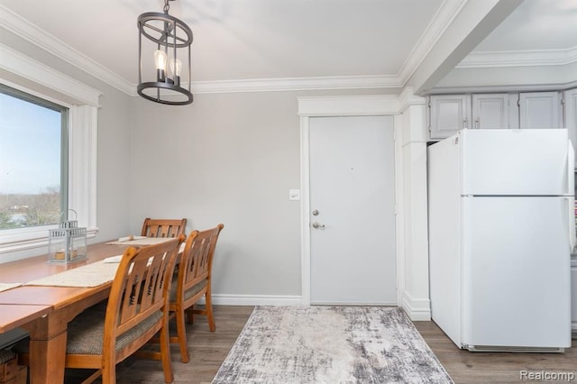 dining space with crown molding, dark wood-type flooring, and a notable chandelier