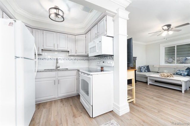 kitchen with crown molding, white appliances, light wood-style floors, open floor plan, and a sink