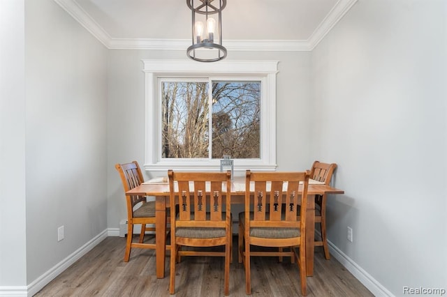 dining area with ornamental molding and light hardwood / wood-style flooring