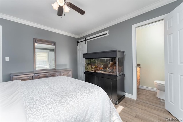 bedroom with ceiling fan, a barn door, light wood-type flooring, and crown molding