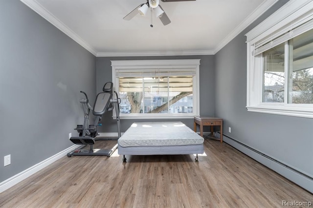 bedroom featuring multiple windows, ceiling fan, ornamental molding, and a baseboard heating unit