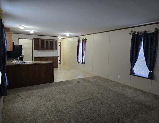 kitchen with black fridge, white cabinetry, and sink