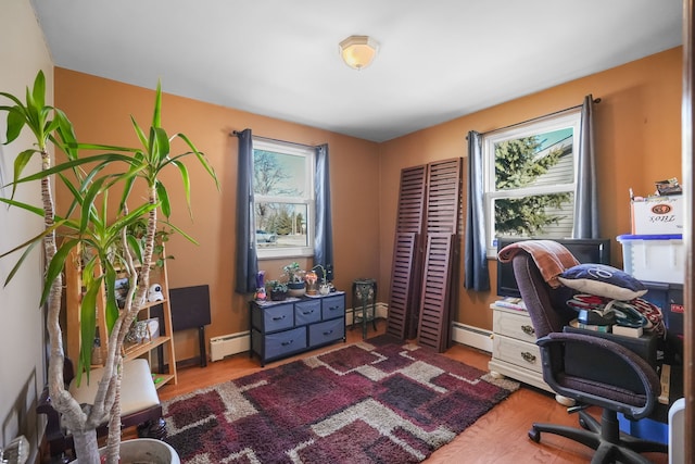 office space featuring wood-type flooring and a baseboard heating unit