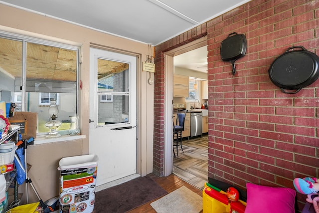 doorway to outside featuring brick wall, parquet floors, and sink