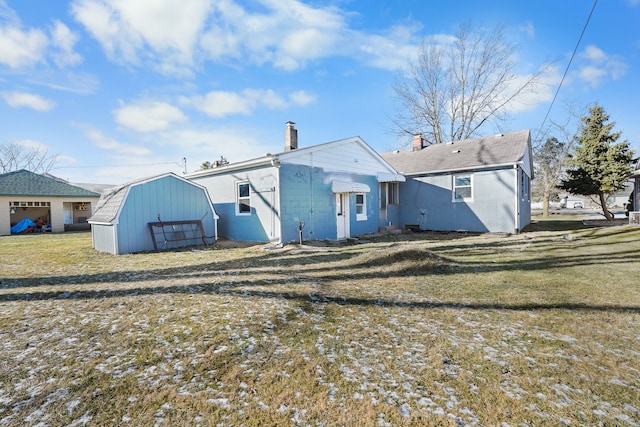 rear view of house featuring a shed and a lawn