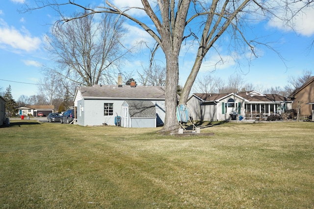 back of property with a lawn and a sunroom