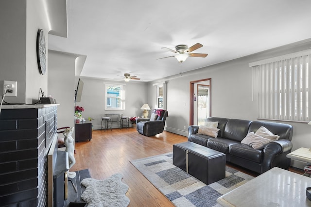 living room with a fireplace, ceiling fan, and hardwood / wood-style floors