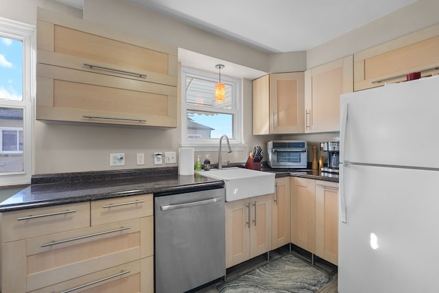 kitchen featuring hanging light fixtures, sink, stainless steel dishwasher, light brown cabinetry, and white fridge