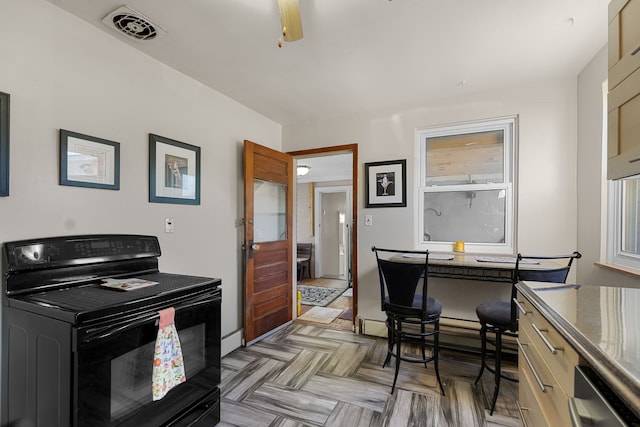 kitchen featuring black electric range oven, parquet flooring, and light brown cabinetry