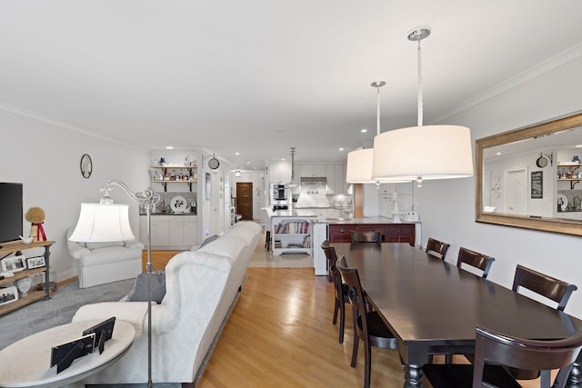 dining space featuring light hardwood / wood-style floors and ornamental molding