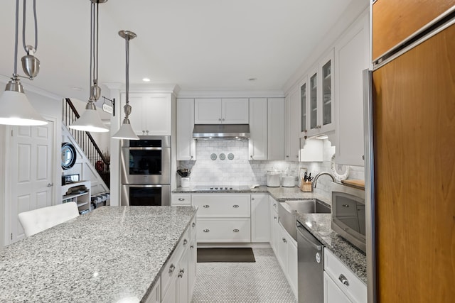 kitchen with white cabinets, sink, decorative light fixtures, light stone counters, and stainless steel appliances