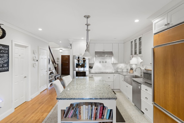 kitchen with pendant lighting, sink, white cabinets, and stainless steel appliances