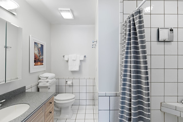 bathroom featuring vanity, tile patterned flooring, a shower with shower curtain, toilet, and tile walls