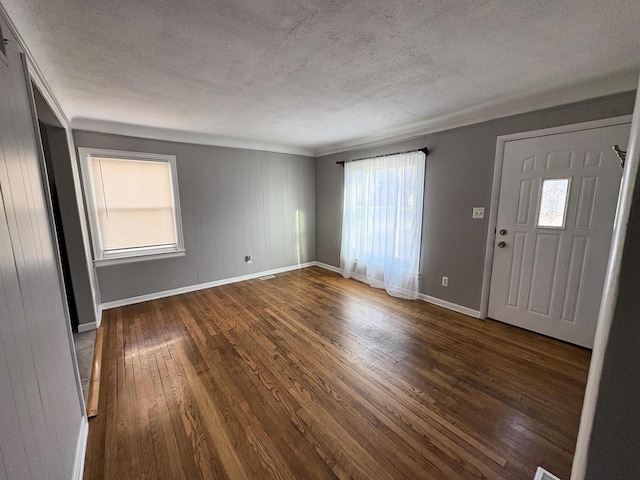 foyer entrance featuring a wealth of natural light, dark hardwood / wood-style flooring, and a textured ceiling