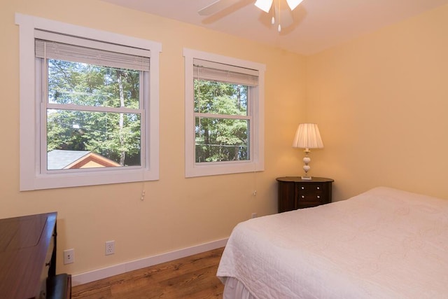 bedroom with multiple windows, ceiling fan, and hardwood / wood-style flooring