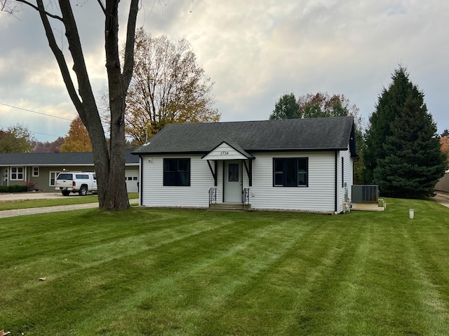 ranch-style home featuring a front lawn and cooling unit