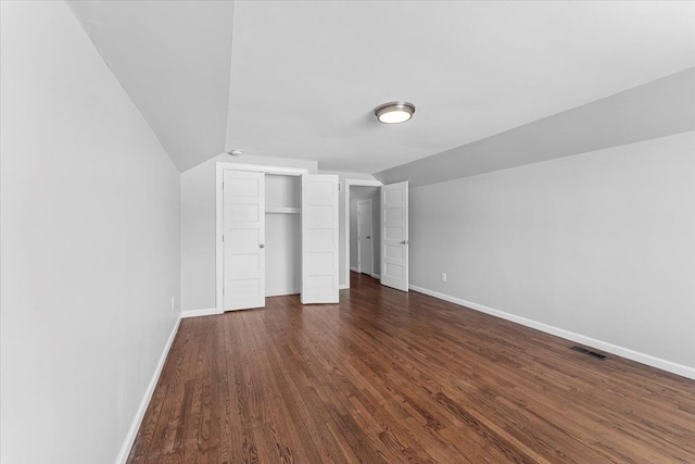 unfurnished bedroom featuring dark hardwood / wood-style floors and vaulted ceiling