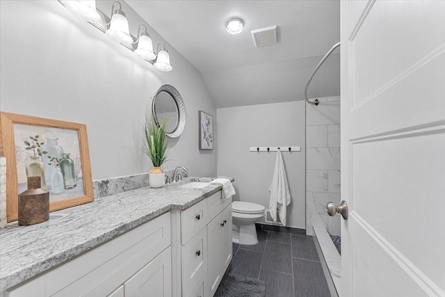 bathroom with vanity, lofted ceiling, toilet, and walk in shower