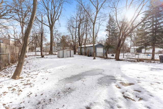 yard covered in snow with a storage shed