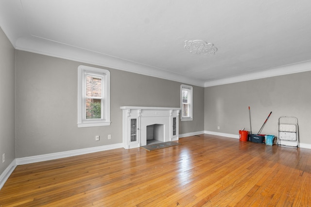 unfurnished living room featuring ornamental molding and light hardwood / wood-style floors