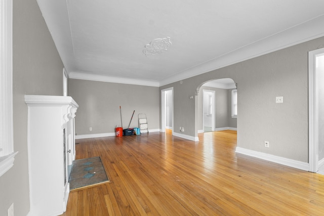 unfurnished living room with ornamental molding and light hardwood / wood-style floors