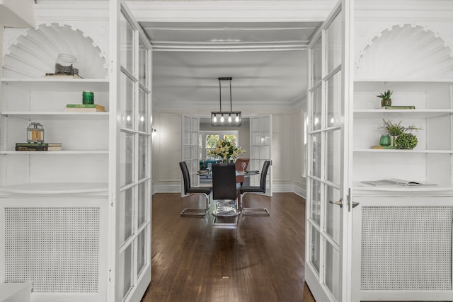 dining room featuring built in shelves, dark hardwood / wood-style floors, and french doors