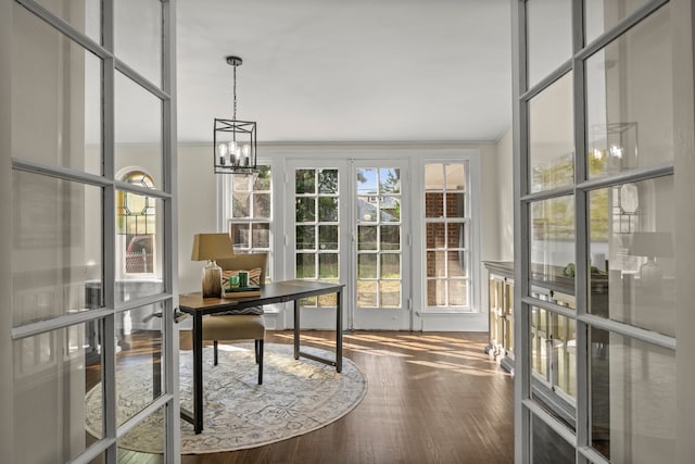 home office featuring crown molding, french doors, a chandelier, and hardwood / wood-style flooring