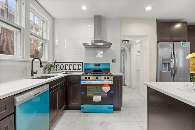 kitchen with tasteful backsplash, dark brown cabinets, stainless steel appliances, sink, and wall chimney range hood