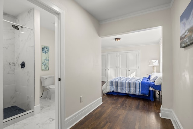 bedroom with hardwood / wood-style floors, ensuite bathroom, and ornamental molding