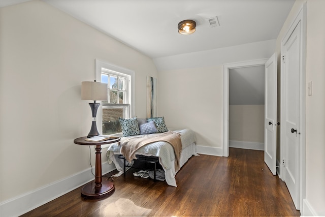 bedroom with dark hardwood / wood-style flooring and lofted ceiling