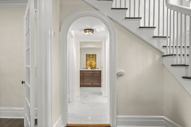 stairway with hardwood / wood-style flooring and ornamental molding