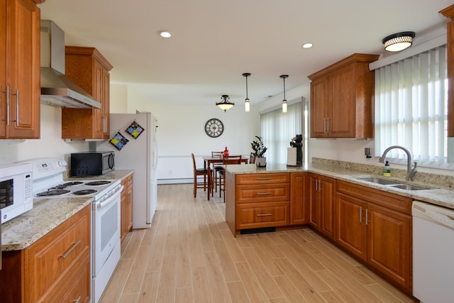 kitchen featuring kitchen peninsula, wall chimney exhaust hood, white appliances, sink, and hanging light fixtures